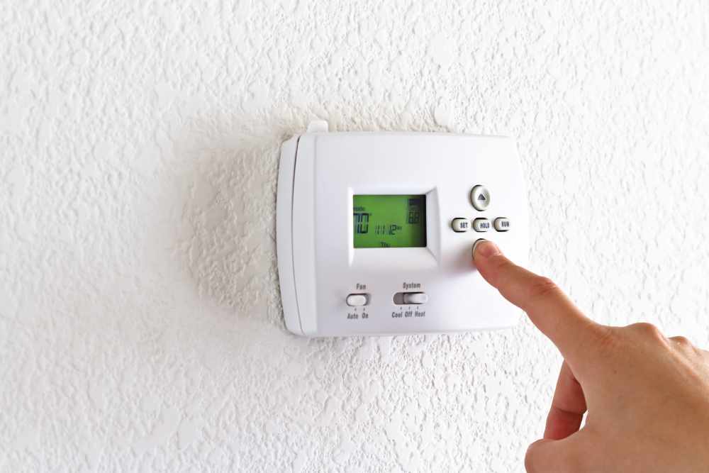 Person programming a thermostat