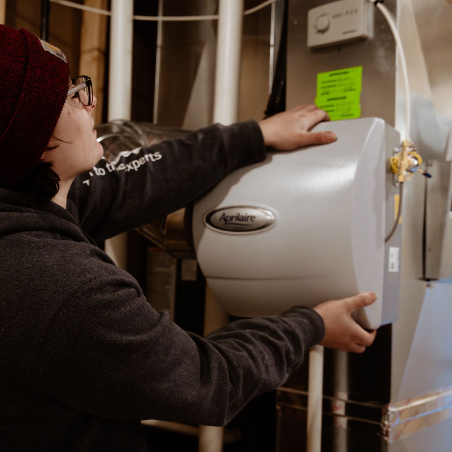 bdg technician installing whole-home humidifier Technician installing a humidifier.