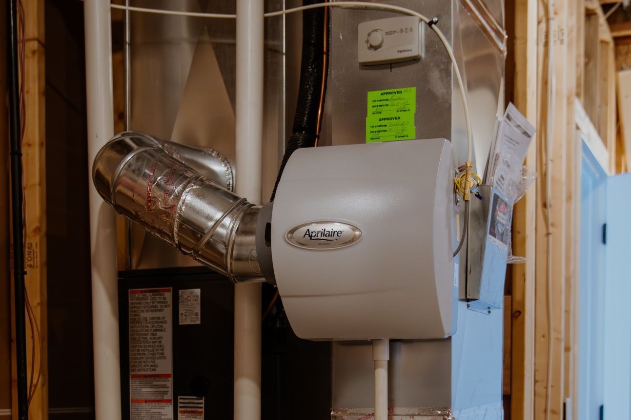 Whole-home humidifier installed to wall inside house.
